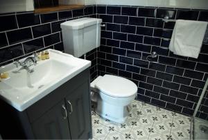 巴茅思The Royal的浴室配有白色卫生间和盥洗盆。