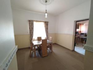 阿布贾Cosmetro Homes Abuja的一间带桌子和窗户的用餐室