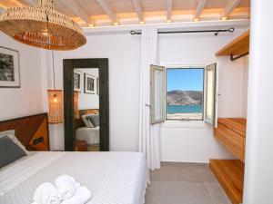 米克诺斯城Enalion Suites的一间卧室配有一张床,享有海景
