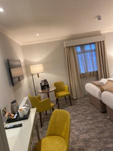 泰恩河畔纽卡斯尔皮尔喀里多尼亚酒店的酒店客房带一张床、一张桌子和椅子