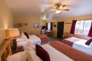 麦金利公园麦金利湖边小屋酒店的酒店客房设有三张床和吊扇。