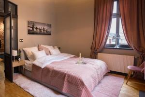 别尔斯克-比亚拉Apartament Podcienie z tarasem Bielsko-Biała Old Town的一间卧室配有一张带粉色毯子的大床
