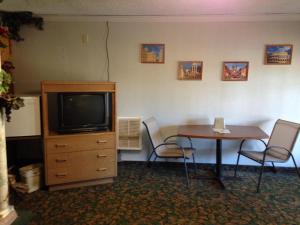 科达伦贝内特湾旅馆的客房设有桌子、电视和桌椅。