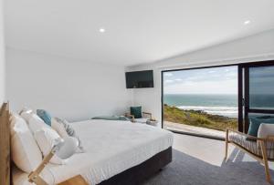Waiuku漂流度假酒店的一间卧室配有一张床,享有海景