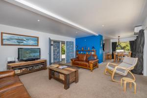 WhangaroaHarbour View的客厅配有家具和电视。