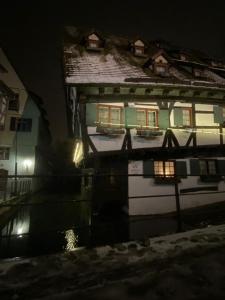 乌尔姆Hotel Schiefes Haus的夜晚在水中反射的房屋
