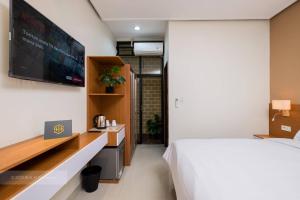 雅加达Blok M Residence的一间卧室配有一张床和一台平面电视