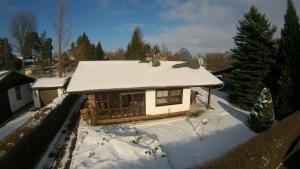 施维洛赫塞Ferienhaus am Schwielochsee的一座带雪盖屋顶的小房子