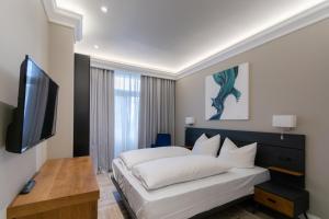 奥斯赛拜-屈隆斯博恩2H Horizon Hotel的一间卧室配有一张床和一台平面电视