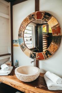 圣弗朗索瓦Résidence de tourisme Domaine Saint-François的浴室水槽和木台面的镜子