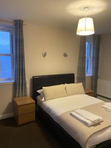 邓巴Hillside Bed & Breakfast Dunbar的一间卧室配有一张带白色床单的床和一扇窗户。