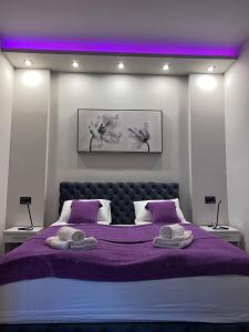贝尔格莱德Rose Lux的一间卧室配有一张紫色床和两条毛巾