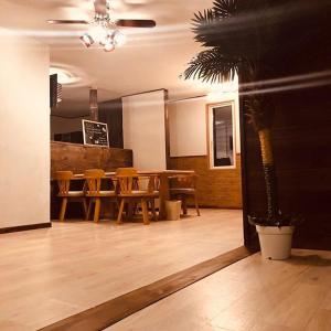 富士河口湖コテージトガワ＜Cottage TOGAWA＞的一间设有桌椅和棕榈树的用餐室