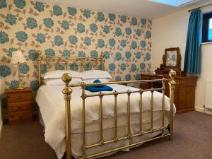 South BrentStation House, Dartmoor and Coast located, Village centre Hotel的一间卧室配有一张带金色床架的床