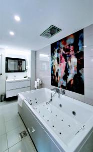 锡纳亚Casa Varful Cu Dor的带浴缸的大型白色浴室和电视。