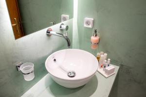 提诺斯蒂诺斯克拉里公寓式酒店的浴室设有白色水槽和镜子