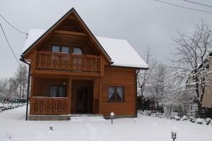 耶维克Chatka z Góralskim Klimatem的木屋,在雪中设有甲板