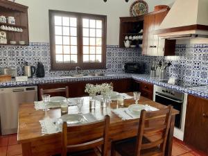 Porto FormosoSuper Mário Houses - Casa dos Moinhos的厨房配有木桌、两把椅子和一张桌子。