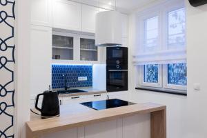 奥普尔Apartament w samym sercu Opola 3的厨房配有白色橱柜和黑色用具