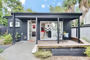 基督城Aspen Studio - Christchurch Holiday Homes的黑色棚子,带甲板和桌子