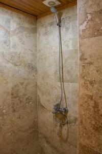格雷梅天使洞穴酒店的带淋浴的浴室(带石墙)