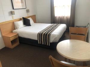 NarweeNarwee Hotel的酒店客房配有一张床铺和一张桌子。