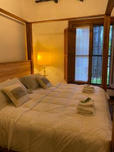 卢汉Don Aniceto - Suites de Campo的卧室配有带毛巾的大型白色床