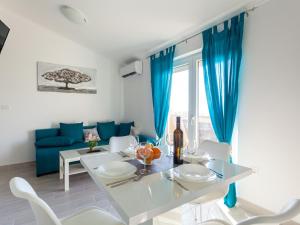 奥米沙利Lavish Apartment in Omi alj with Rooftop Terrace的一间设有蓝色窗帘和桌椅的用餐室