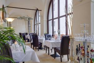 Drehna弗斯蒂申德瑞赫城堡酒店的餐厅设有白色的桌椅和窗户。