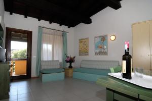 罗通多港Residence Portorotondo Tre的带沙发和一瓶葡萄酒的客厅