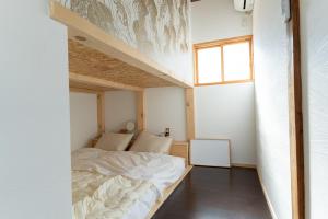 磐城Guesthouse & Kitchen Hace的一间小卧室,配有床和窗户