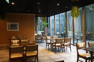 曼谷Amara Bangkok Hotel的用餐室设有桌椅和窗户。