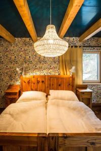 布莱堡Südalpen Lofts的一间卧室配有一张大床和一个吊灯。