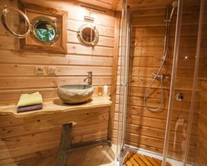圣迪耶Gaïa - Les Cabanes du Chêne Rouvre的木制浴室设有水槽和淋浴