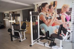 纳塔尔Flat Natal - Localização TOP e WIFI的一间房间,有两名女性在健身房锻炼