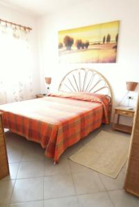 罗萨岛Tanca della Torre Trilocale vista mare的一间卧室配有一张带铺着平底毯的床