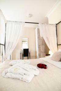 诺维萨德加尔尼丹什酒店的一张带白色毛巾和玫瑰的床