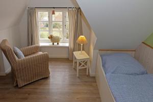 佩尔沃姆Alte Stellmacherei的卧室配有床、椅子和窗户。