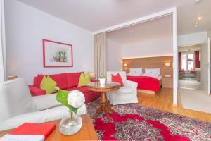 圣沃尔夫冈西霍夫公寓的客厅配有红色的沙发和红色的床