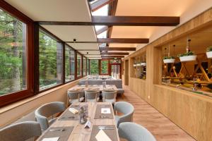 卡奇山口卡奇山法肯斯特诺俱乐部酒店的餐厅设有长桌子、椅子和窗户。