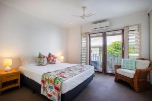 道格拉斯港The Queenslander Fullmoon的卧室配有床、椅子和窗户。
