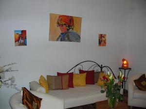 马拉喀什艾琳摩洛哥传统庭院旅馆的客厅配有沙发和墙上的绘画