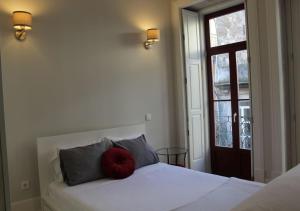 波尔图Oporto Coliseum Studio的一间卧室配有一张红色枕头的床