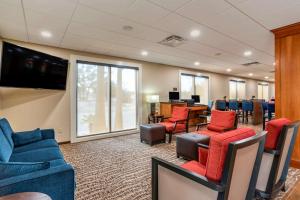 尼斯维尔Comfort Suites Niceville Near Eglin Air Force Base的一间设有桌椅和电视的等候室