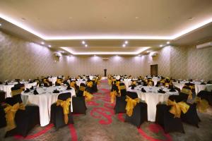 雅加达PGC西利利坦法维酒店的宴会厅配有白色桌子和黄色弓