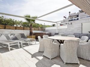 锡切斯Sitges Spaces Mediterranean Apartments 4 bedroom, 4 bathroom, Huge Terrace, Jacuzzi- Sleeps 9的庭院设有藤椅和桌子。
