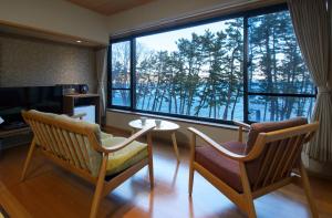 釜石蓬莱罐海滩美食酒店的客房设有一张桌子、两把椅子和一个大窗户