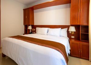 塔克纳Retama Hotel的一间卧室配有一张白色大床和木柜