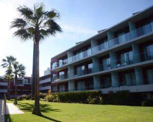 费拉古多Agua Hotels Riverside的一座建筑前的棕榈树