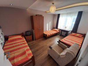 尼什Apartments "Predah kod Baraća"的客房设有两张床、一张沙发和一张床。